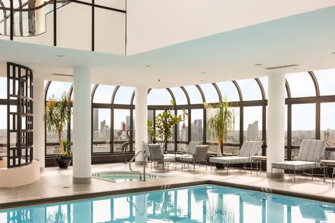 a dining hall with stainless steel appliances granite countertop a coffee table and chairs next to a large window