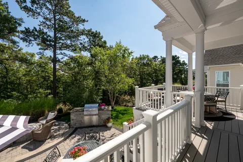 a view of a deck with two couches chairs with wooden fence