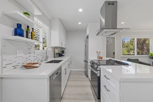 a kitchen with stainless steel appliances a sink stove and cabinets