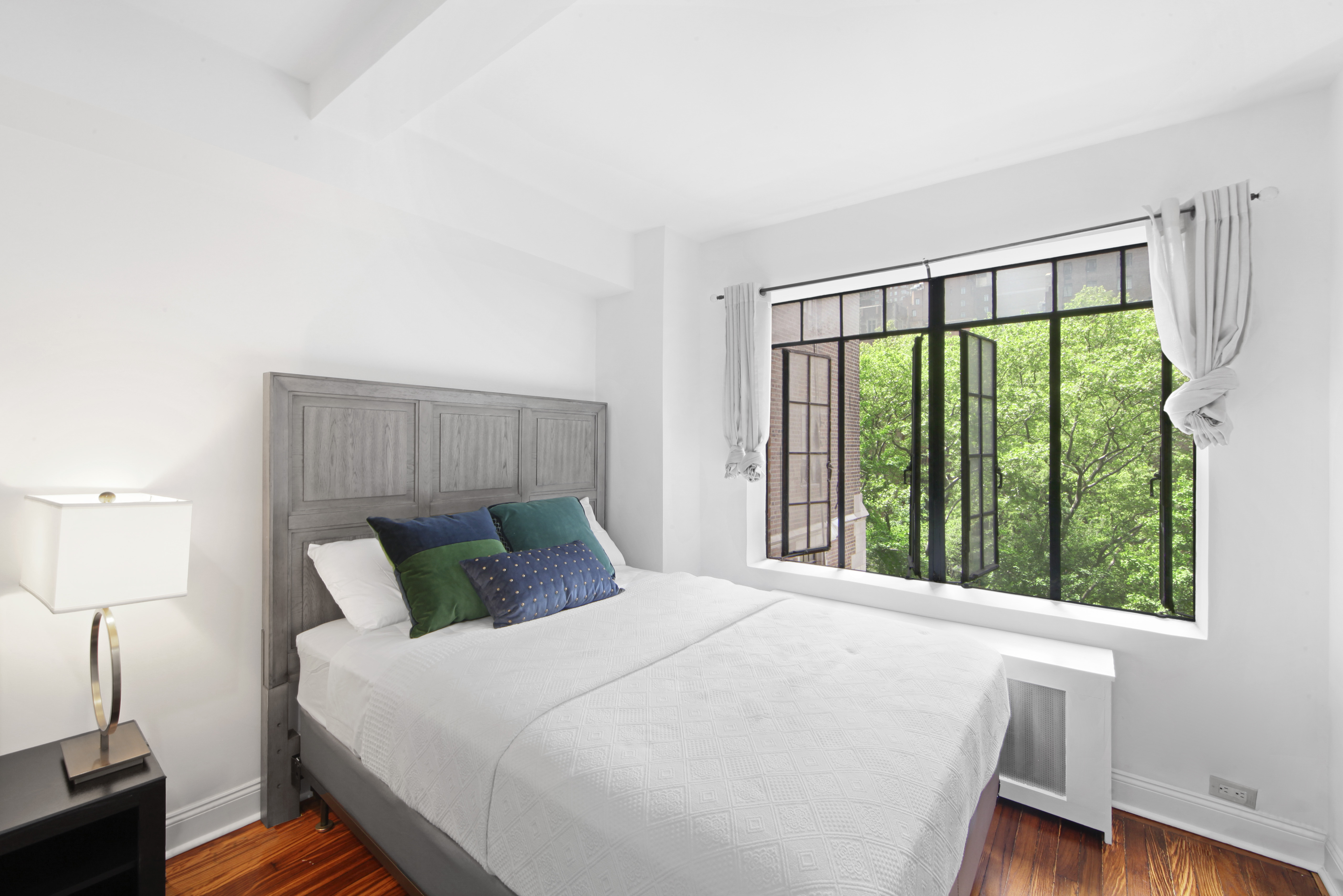 25 Tudor City Place, Unit 508 Manhattan, NY 10017 - Photo 2 of 17 a bed sitting in a bedroom next to a window