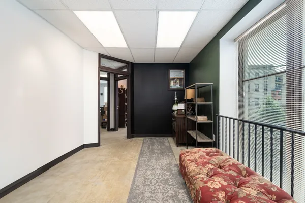 a view of a hallway with wooden floor and a bathroom