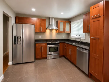 a kitchen with stainless steel appliances granite countertop a refrigerator a sink and a stove