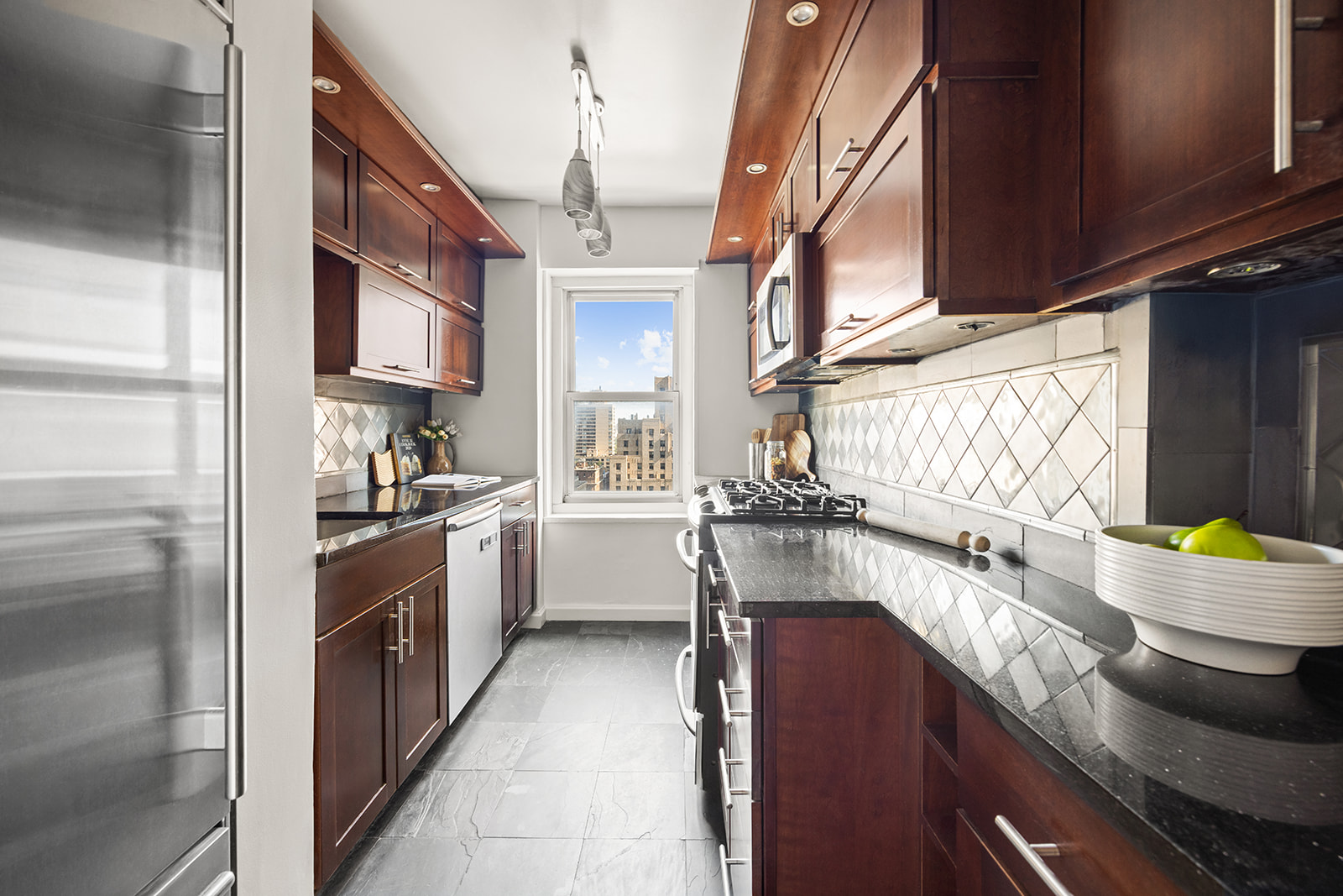 159 West 53rd Street, Unit 27H Manhattan, NY 10019 - Photo 4 of 15 a kitchen with a sink appliances cabinets and a window