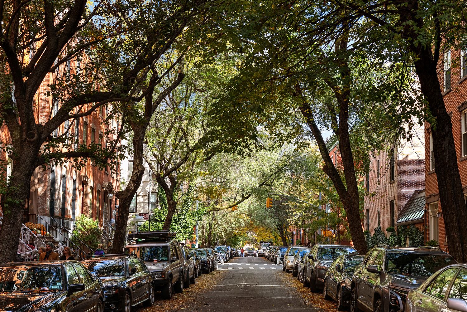 an outdoor space with lots of cars parked on the roadside