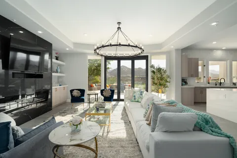 a living room with furniture kitchen view and a chandelier