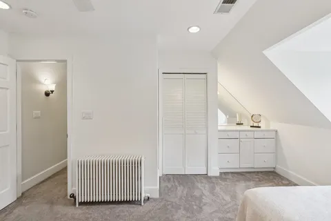 a hallway with white cabinets and sink