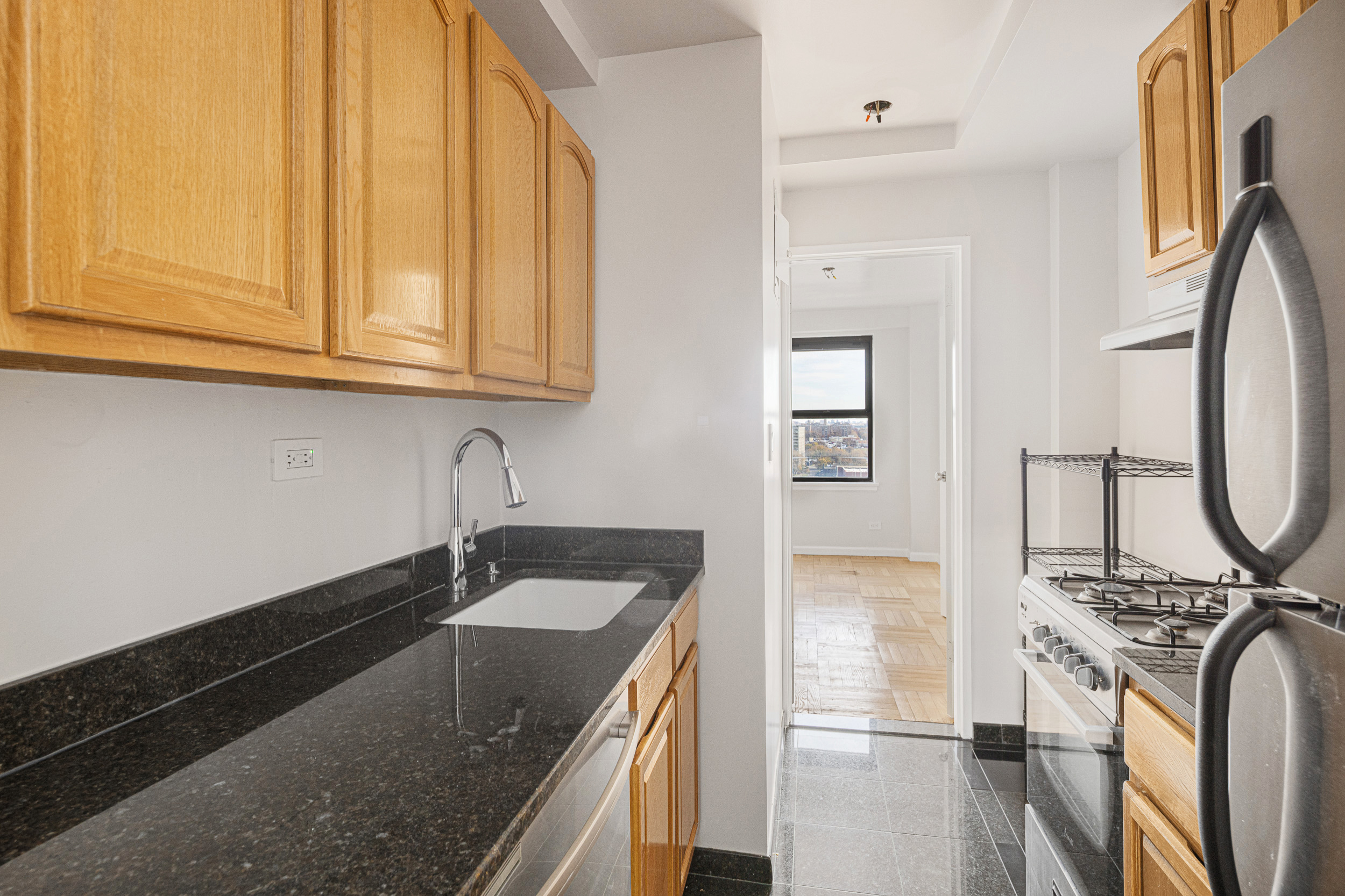 460 East 79th Street, Unit 15F Manhattan, NY 10075 - Photo 5 of 8 a kitchen with stainless steel appliances granite countertop a sink stove and refrigerator