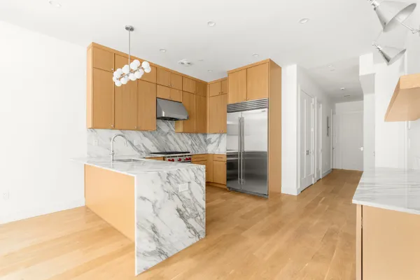 a kitchen with stainless steel appliances granite countertop a refrigerator and a stove