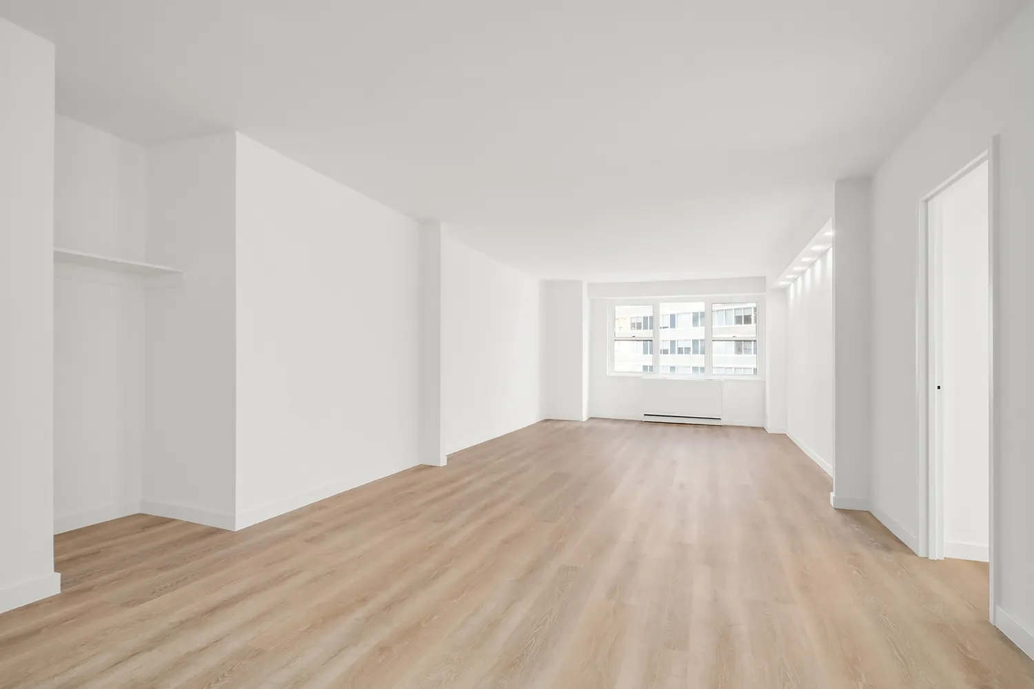 a view of empty room with wooden floor
