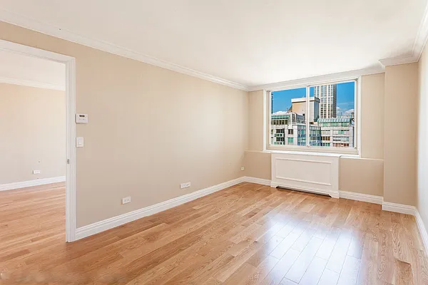 30 West 63rd Street, Unit 28L Manhattan, NY 10023 - Photo 10 of 11 an empty room with wooden floor and windows