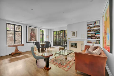 a living room with furniture a fireplace and large windows