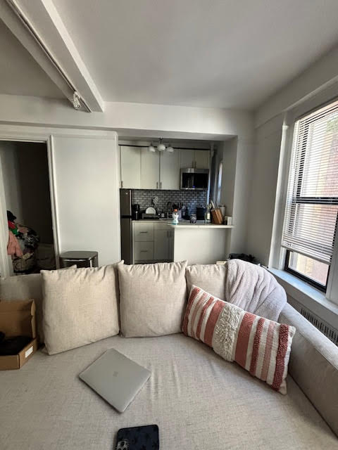 319 East 50th Street, Unit 10L Manhattan, NY 10022 - Photo 6 of 11 a living room with furniture and a large window