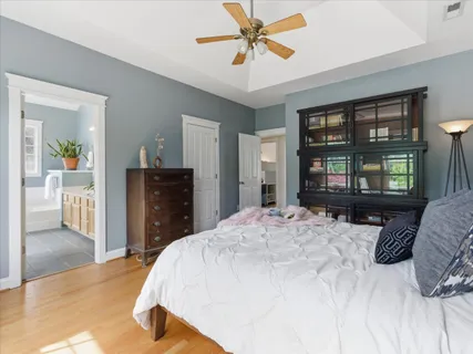 a bedroom with a bed next to a window and a wooden floor