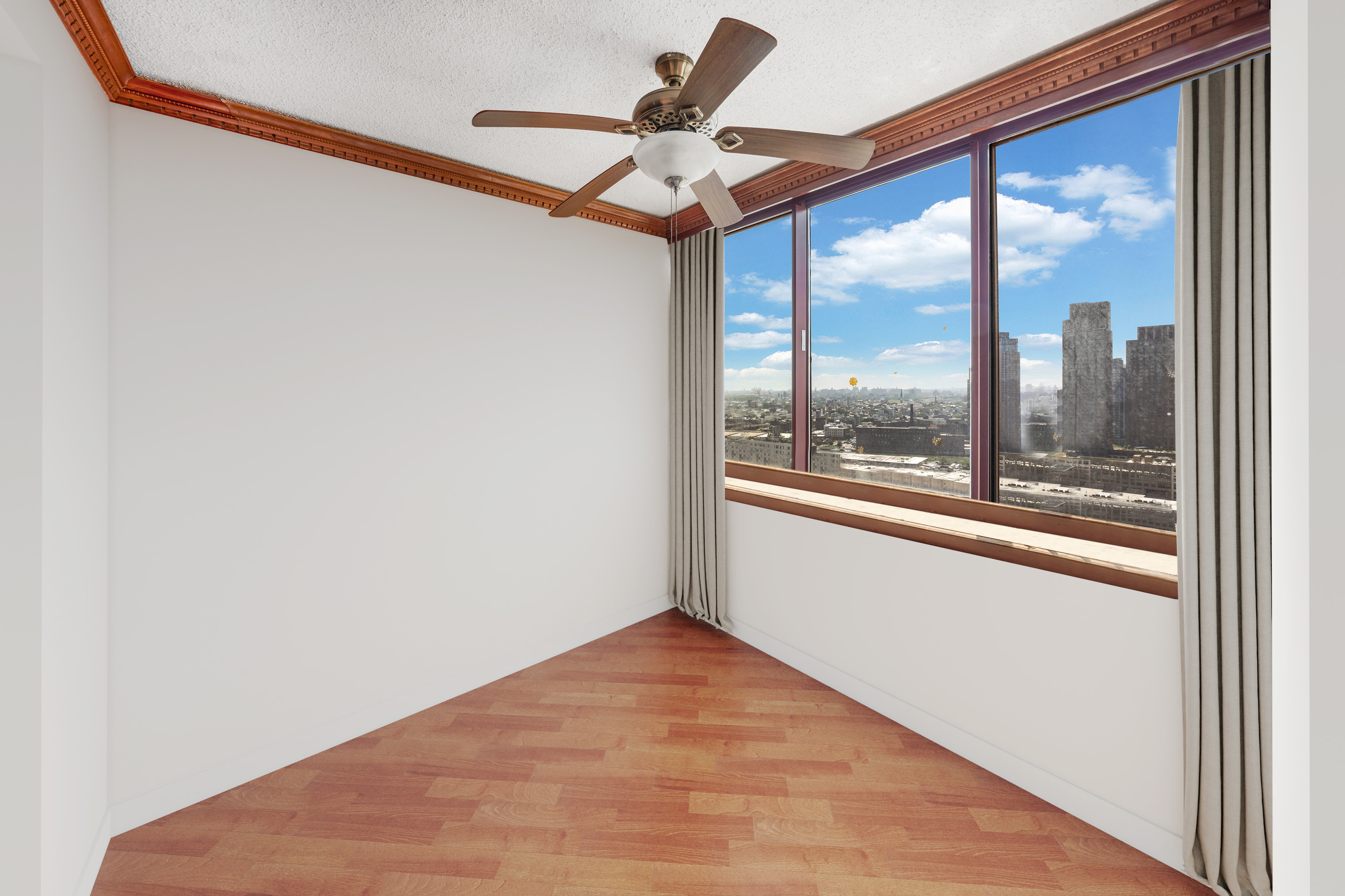 4-74 48th Avenue, Unit 27A Queens, NY 11109 - Photo 5 of 11 a view of an empty room with a window