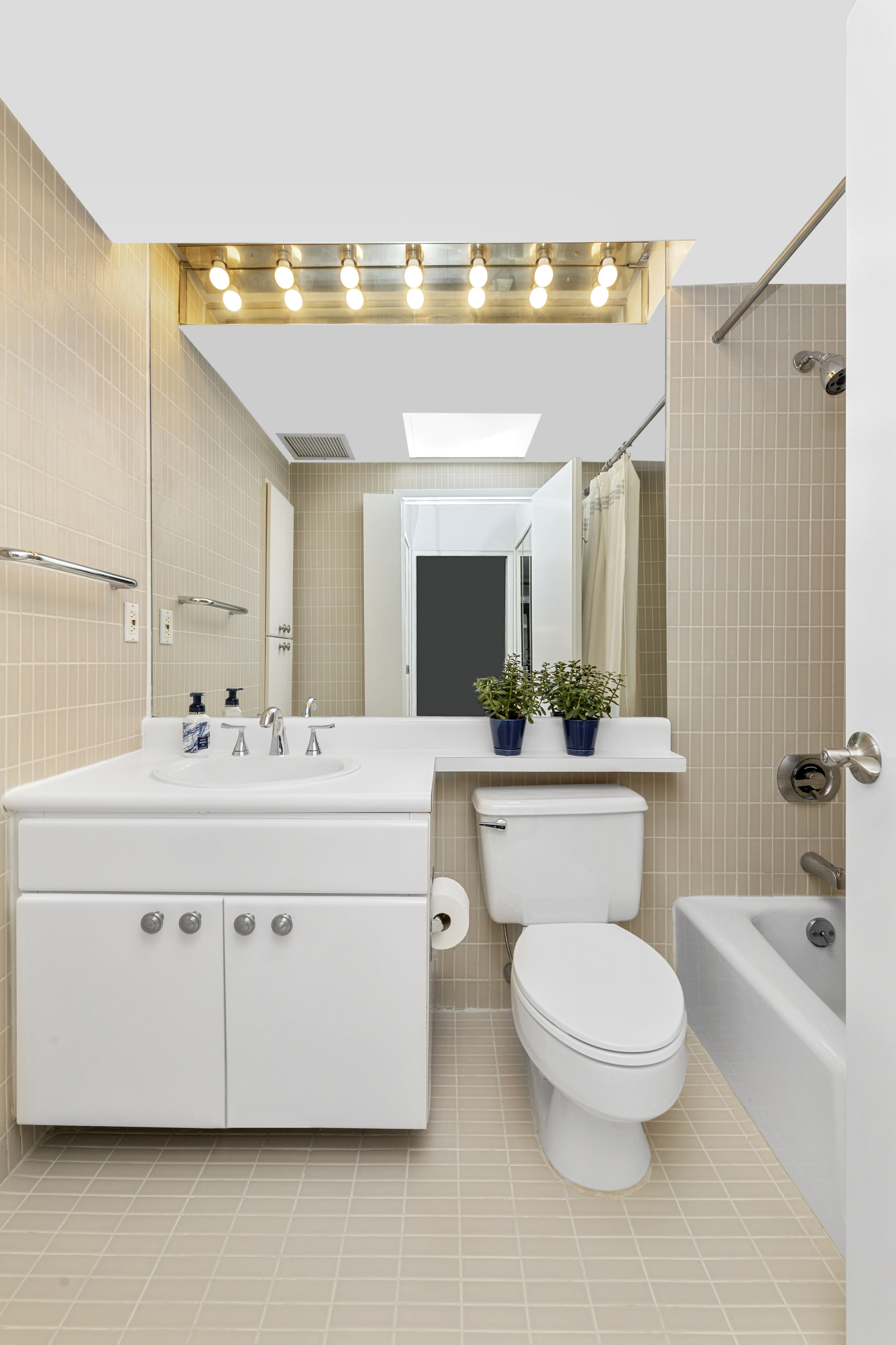 400 East 70th Street, Unit 1108 Manhattan, NY 10021 - Photo 6 of 8 a bathroom with a toilet a sink a mirror and a bathtub