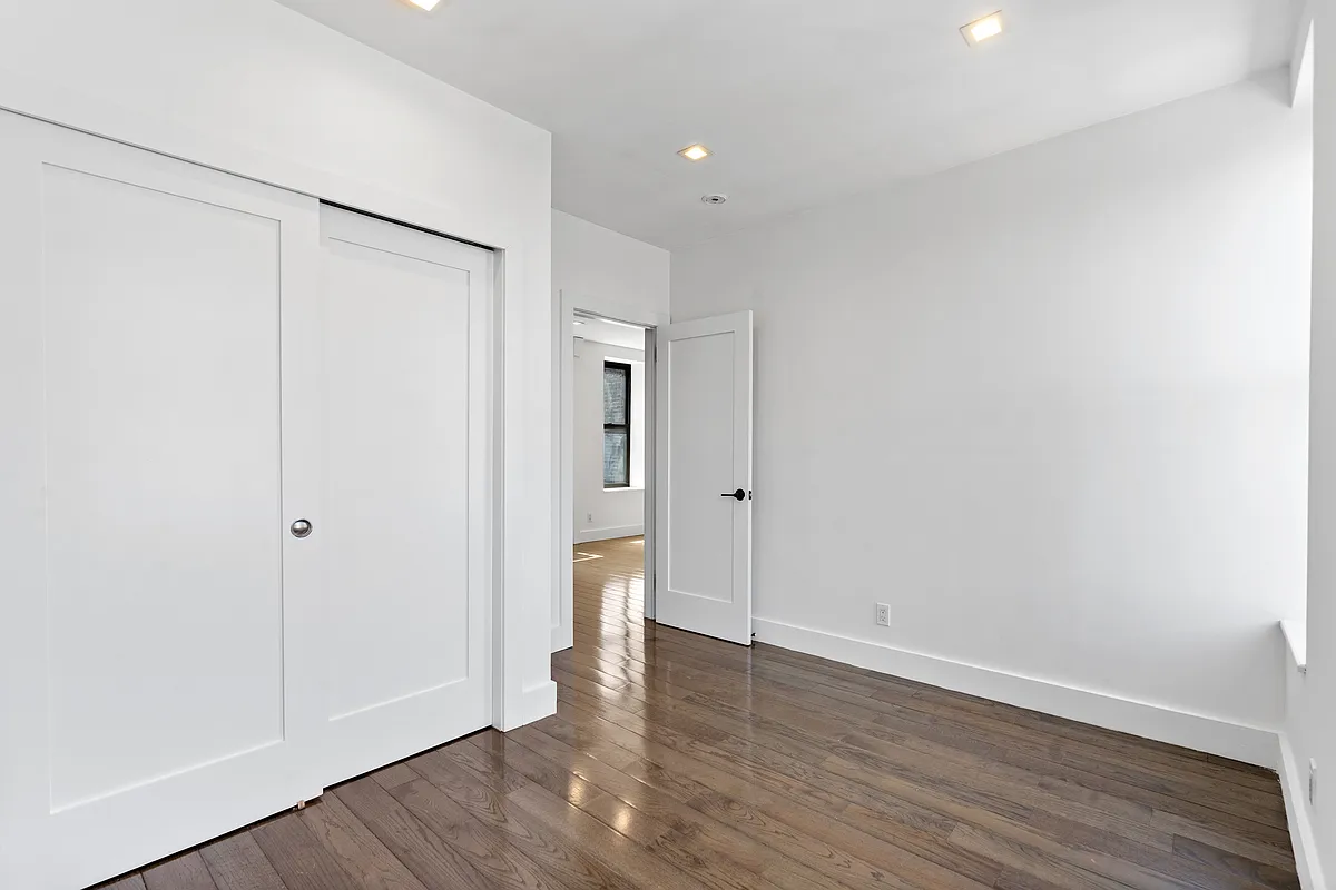 152 Thompson Street, Unit 5E Manhattan, NY 10012 - Photo 6 of 10 a view of an empty room with wooden floor