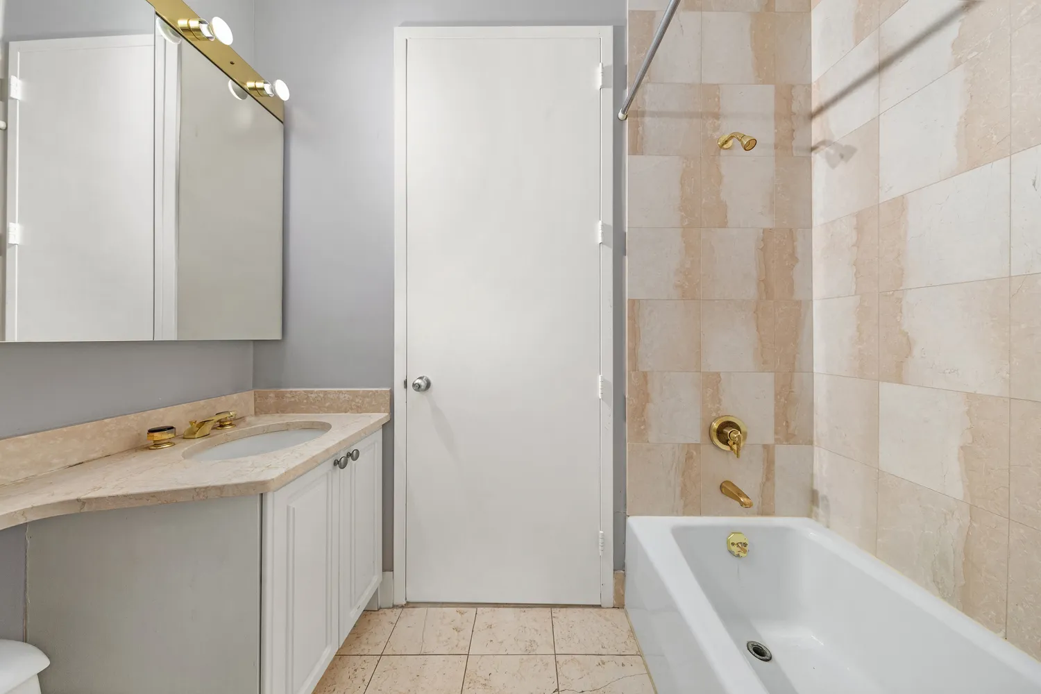 a bathroom with a tub sink and mirror