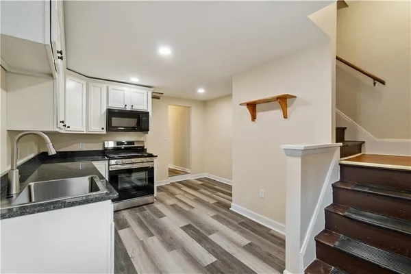 a kitchen with sink a microwave and cabinets