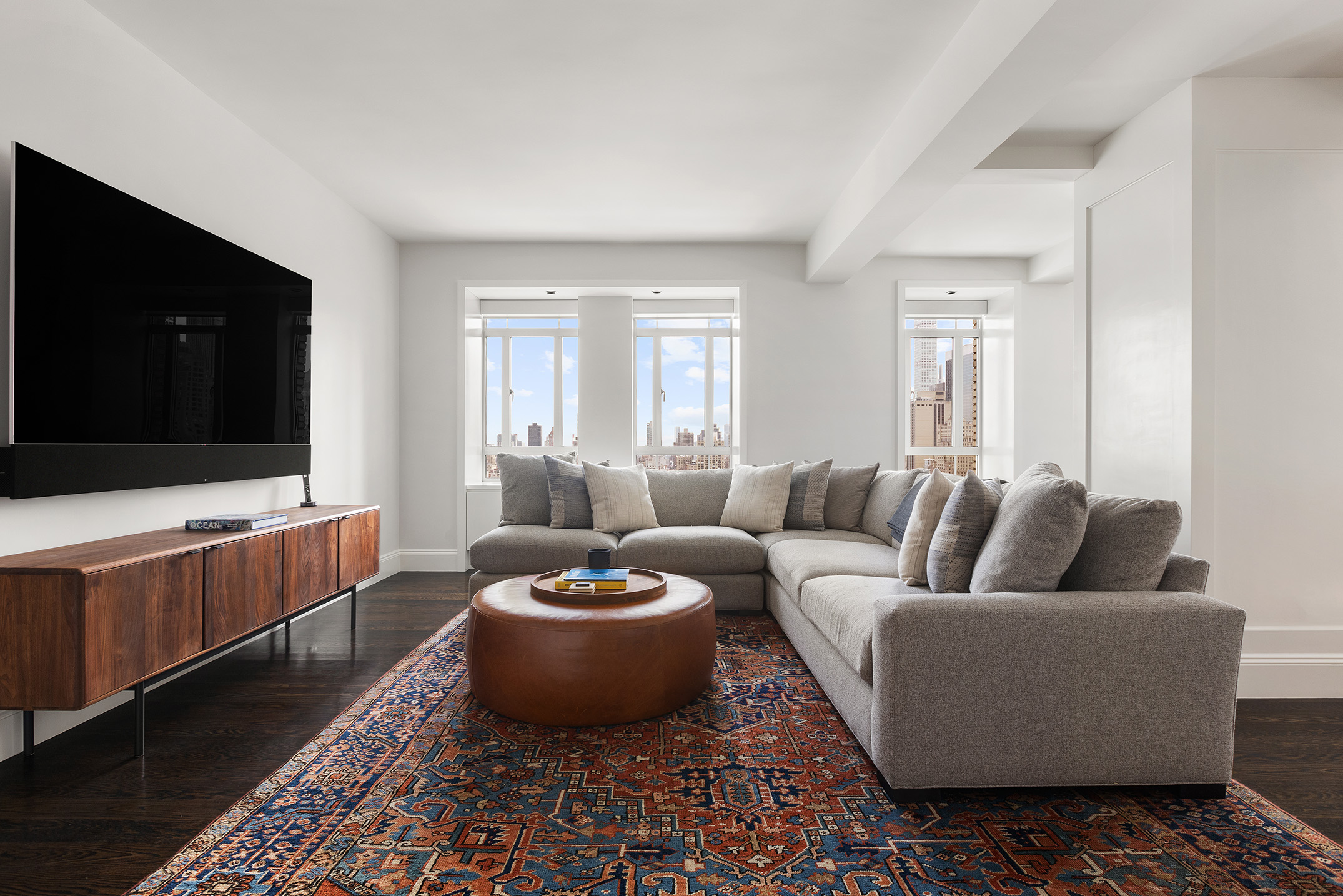 25 Central Park West, Unit 27J Manhattan, NY 10023 - Photo 4 of 13 a living room with furniture and a flat screen tv