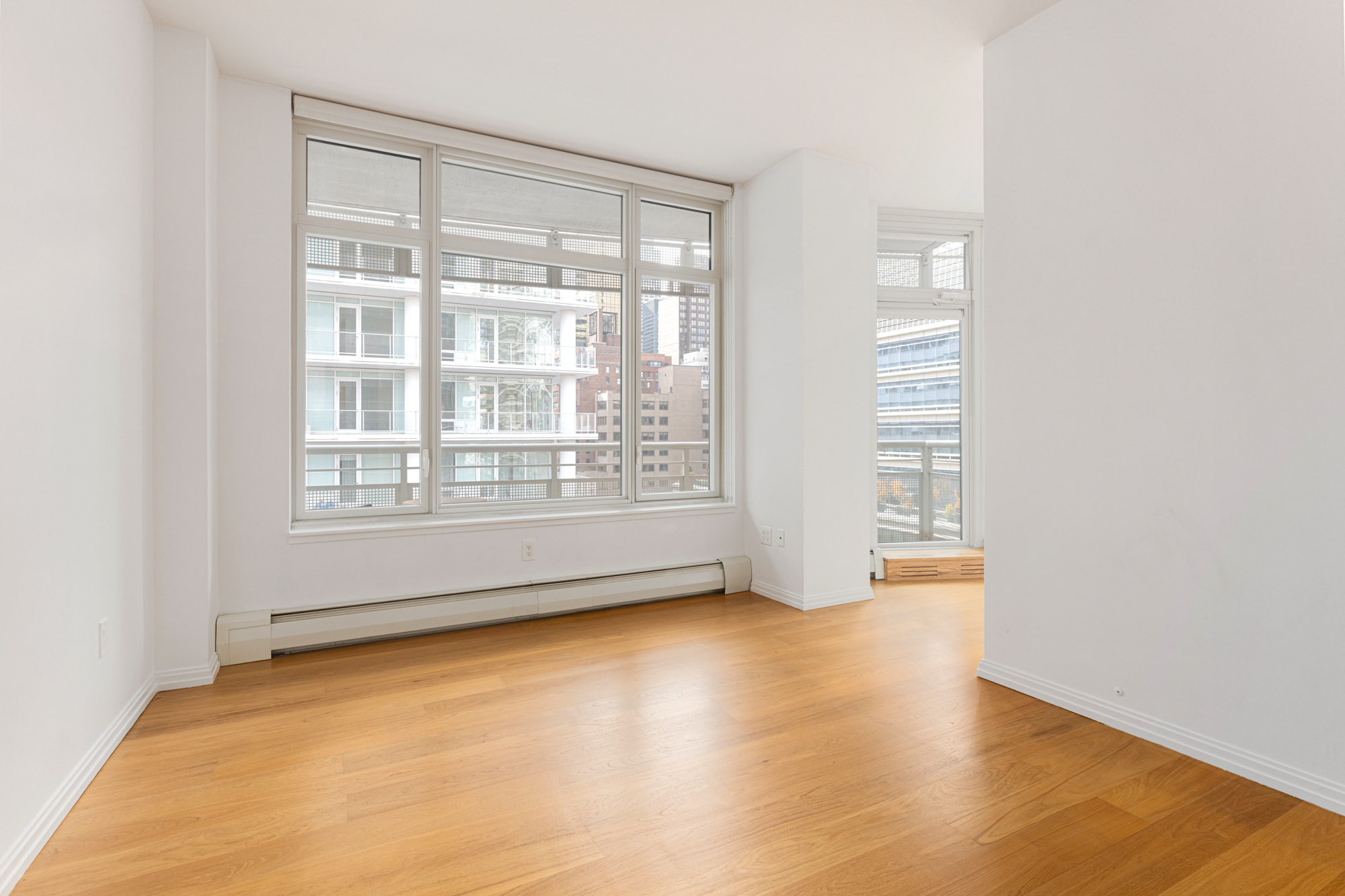 205 East 59th Street, Unit 10B Manhattan, NY 10022 - Photo 5 of 10 a view of an empty room with a window and wooden floor