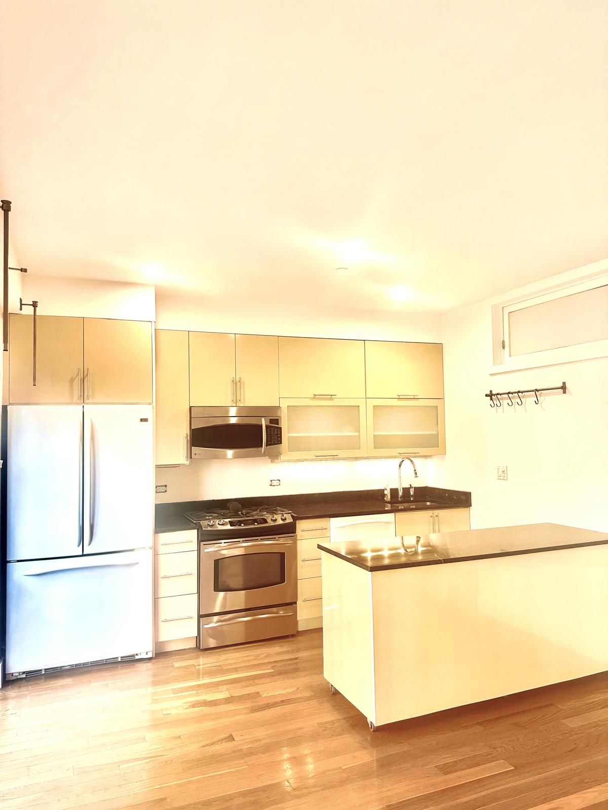 221 West 148th Street, Unit 4A Manhattan, NY 10039 - Photo 4 of 11 a kitchen with stainless steel appliances granite countertop a sink and a refrigerator