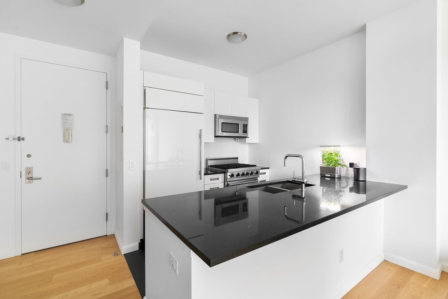 46-30 Center Boulevard, Unit 406 Queens, NY 11109 - Photo 5 of 24 a kitchen with stainless steel appliances granite countertop a sink and a refrigerator