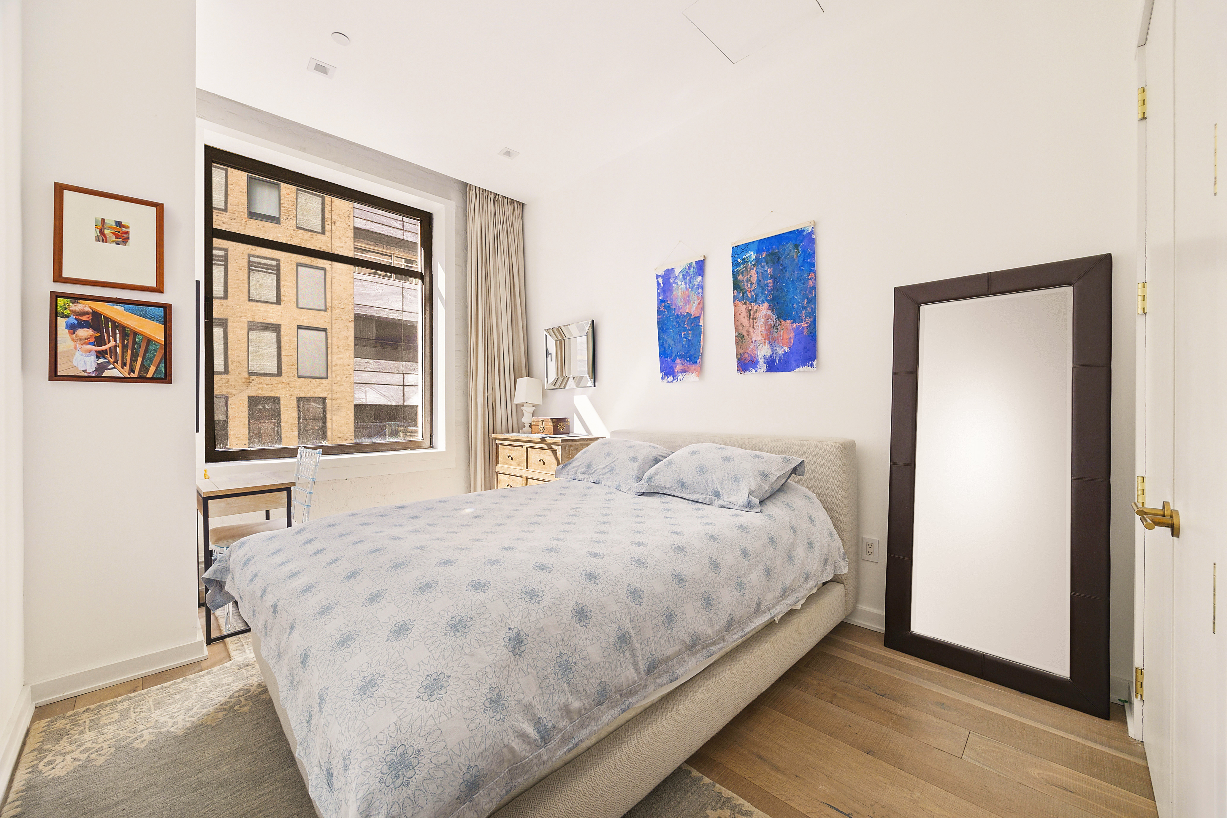 181 Hudson Street, Unit 2B Manhattan, NY 10013 - Photo 2 of 10 a large bed sitting in a bedroom next to a window