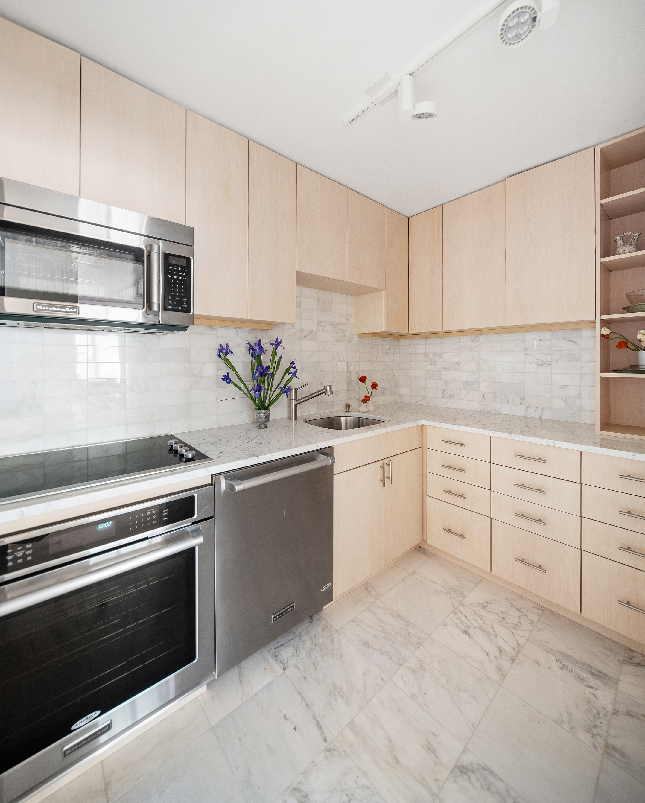 1065 Park Avenue, Unit 5BC Manhattan, NY 10128 - Photo 3 of 16 a kitchen with granite countertop white cabinets and stainless steel appliances