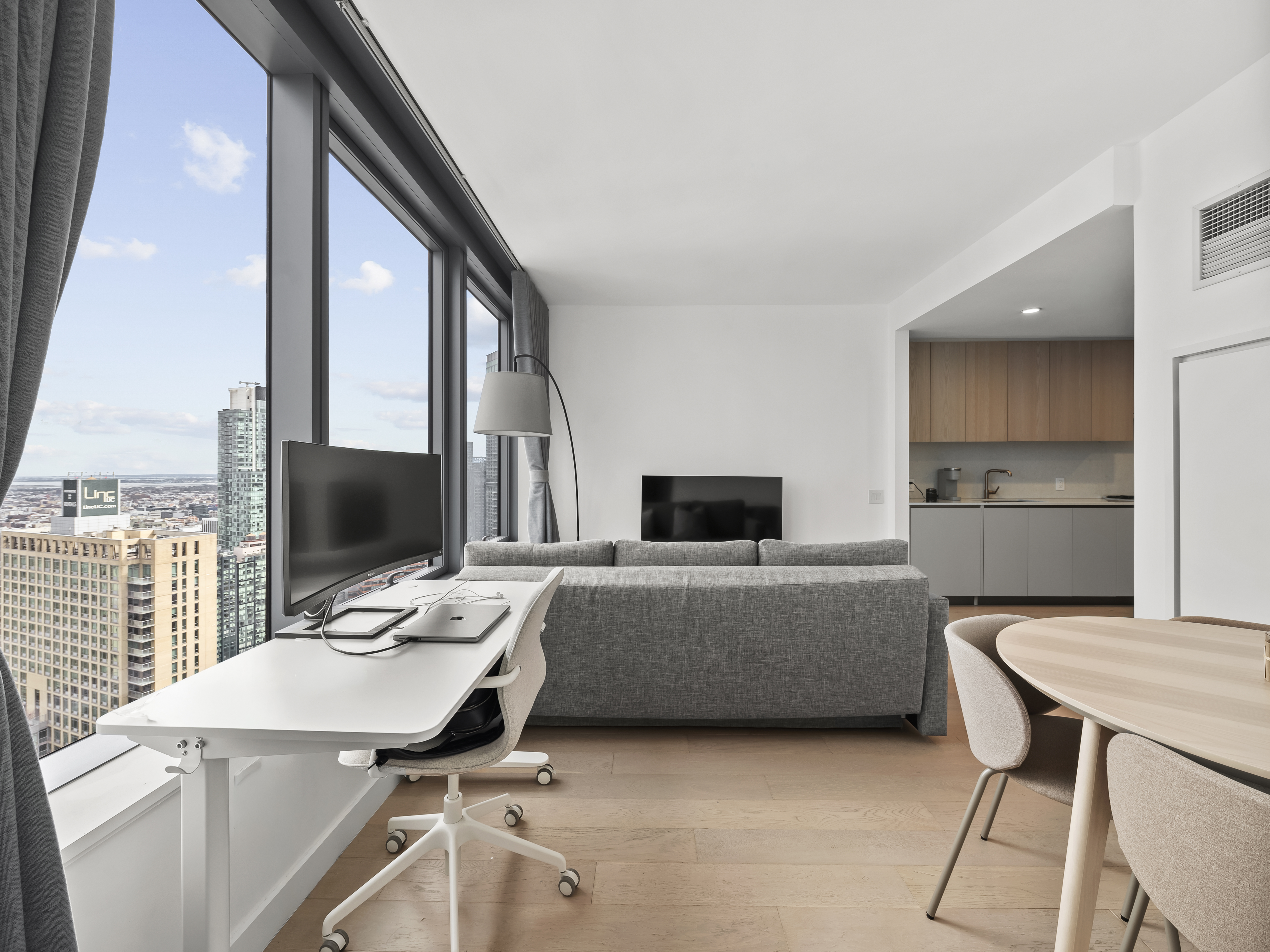 45-3 Court Square, Unit 4406 Queens, NY 11101 - Photo 3 of 22 a living room with furniture and flat screen tv