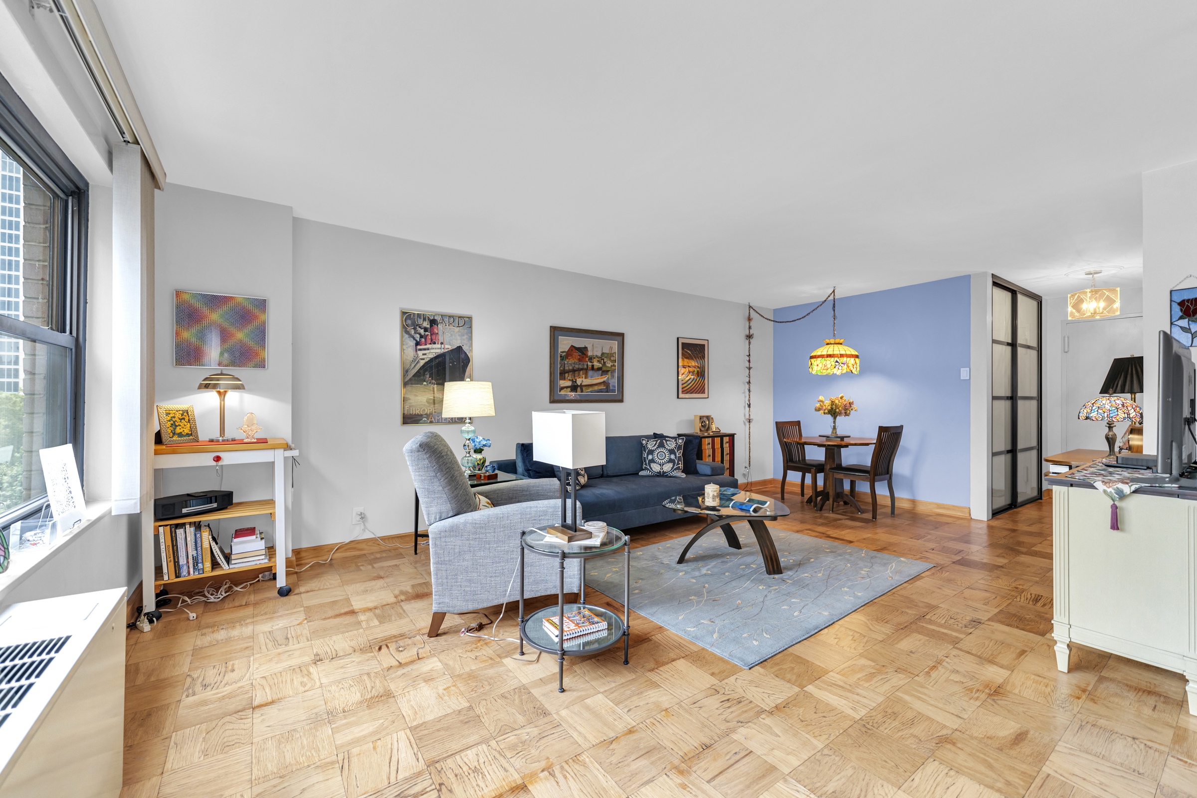 180 West End Avenue, Unit 9P Manhattan, NY 10023 - Photo 7 of 13 a living room with furniture a rug and a large window
