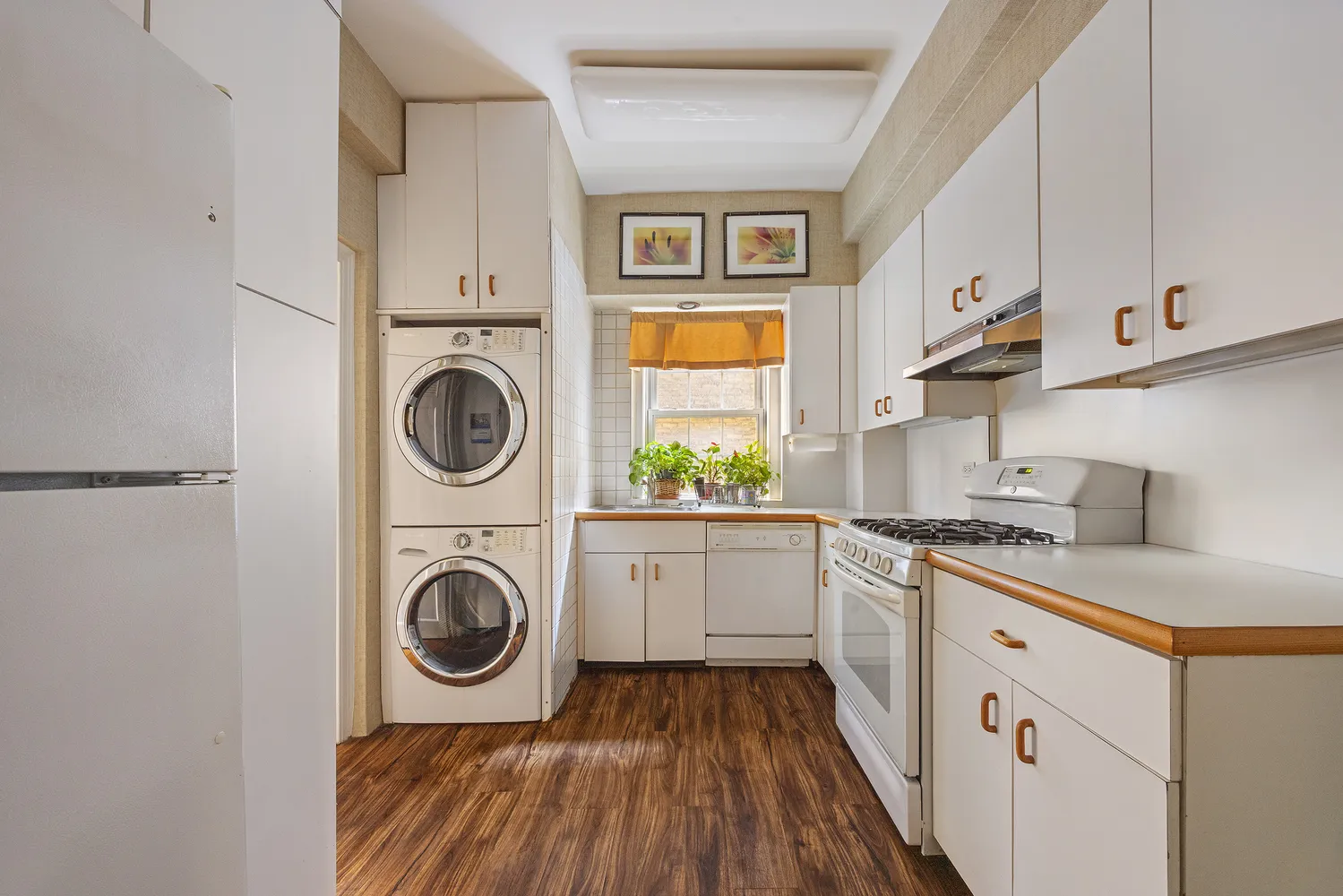 a kitchen with cabinets washer and dryer