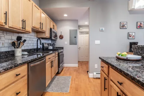 a kitchen with stainless steel appliances granite countertop a sink a stove and a refrigerator