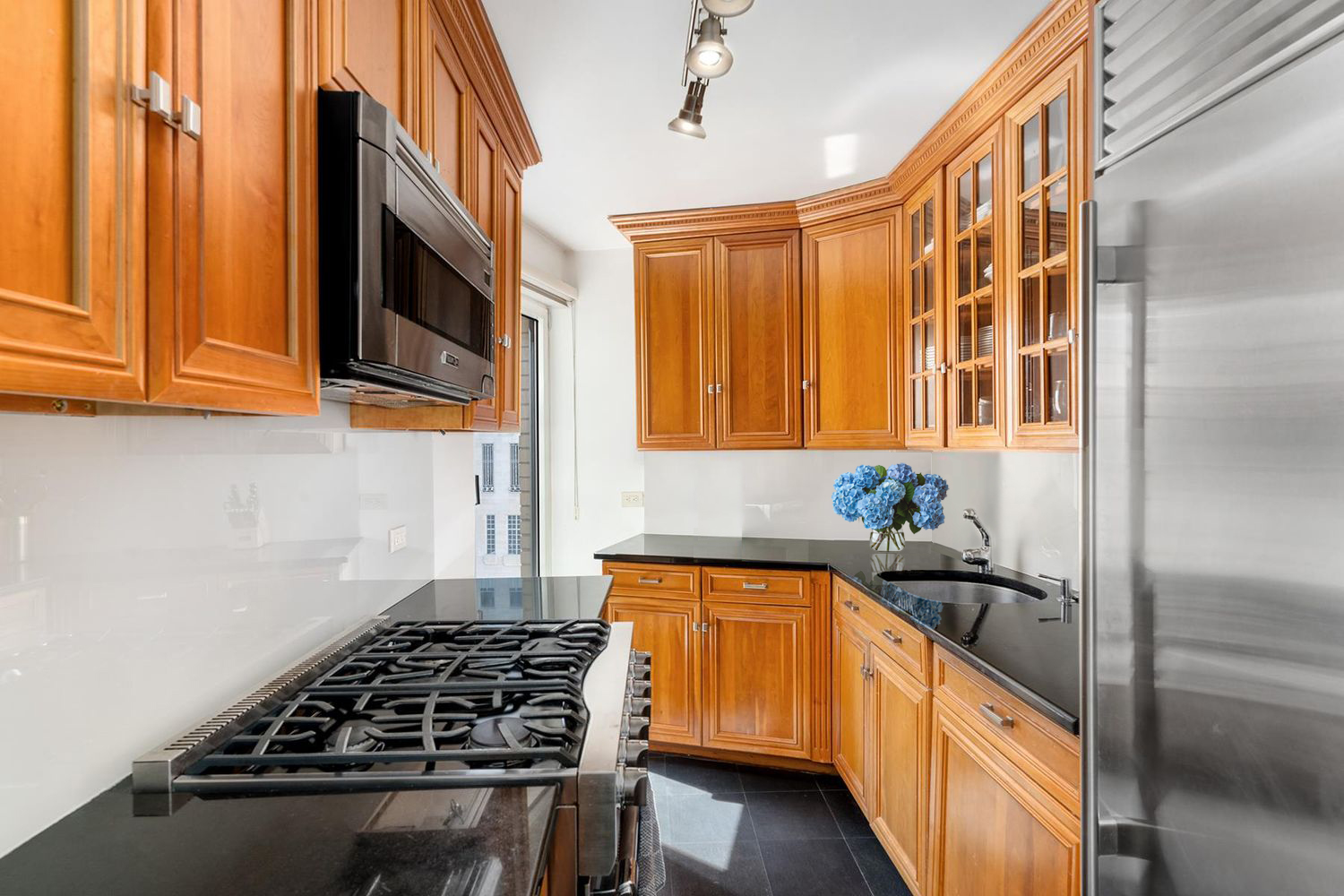 200 Central Park South, Unit 14A Manhattan, NY 10019 - Photo 6 of 7 a kitchen with stainless steel appliances a stove a sink and a microwave