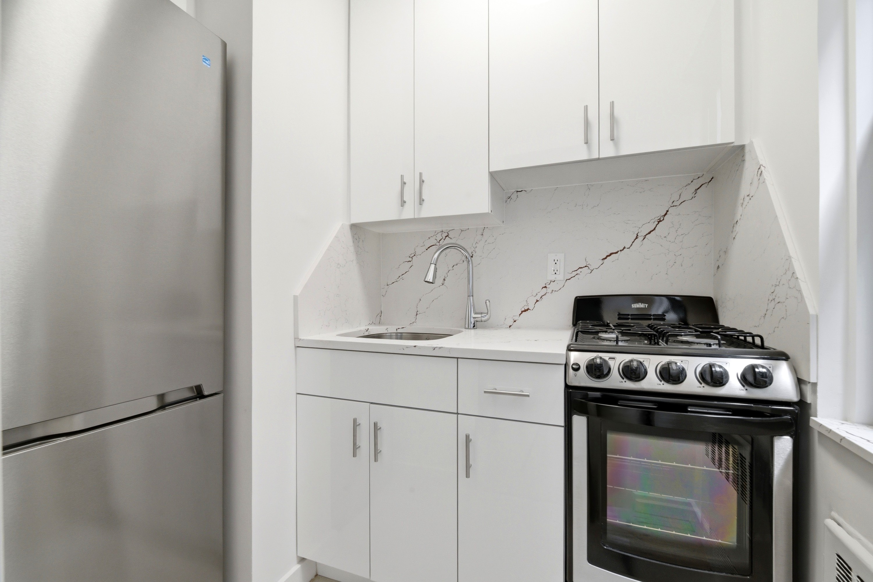240 East 46th Street, Unit 8J Manhattan, NY 10017 - Photo 6 of 11 a stove top oven sitting inside of a kitchen