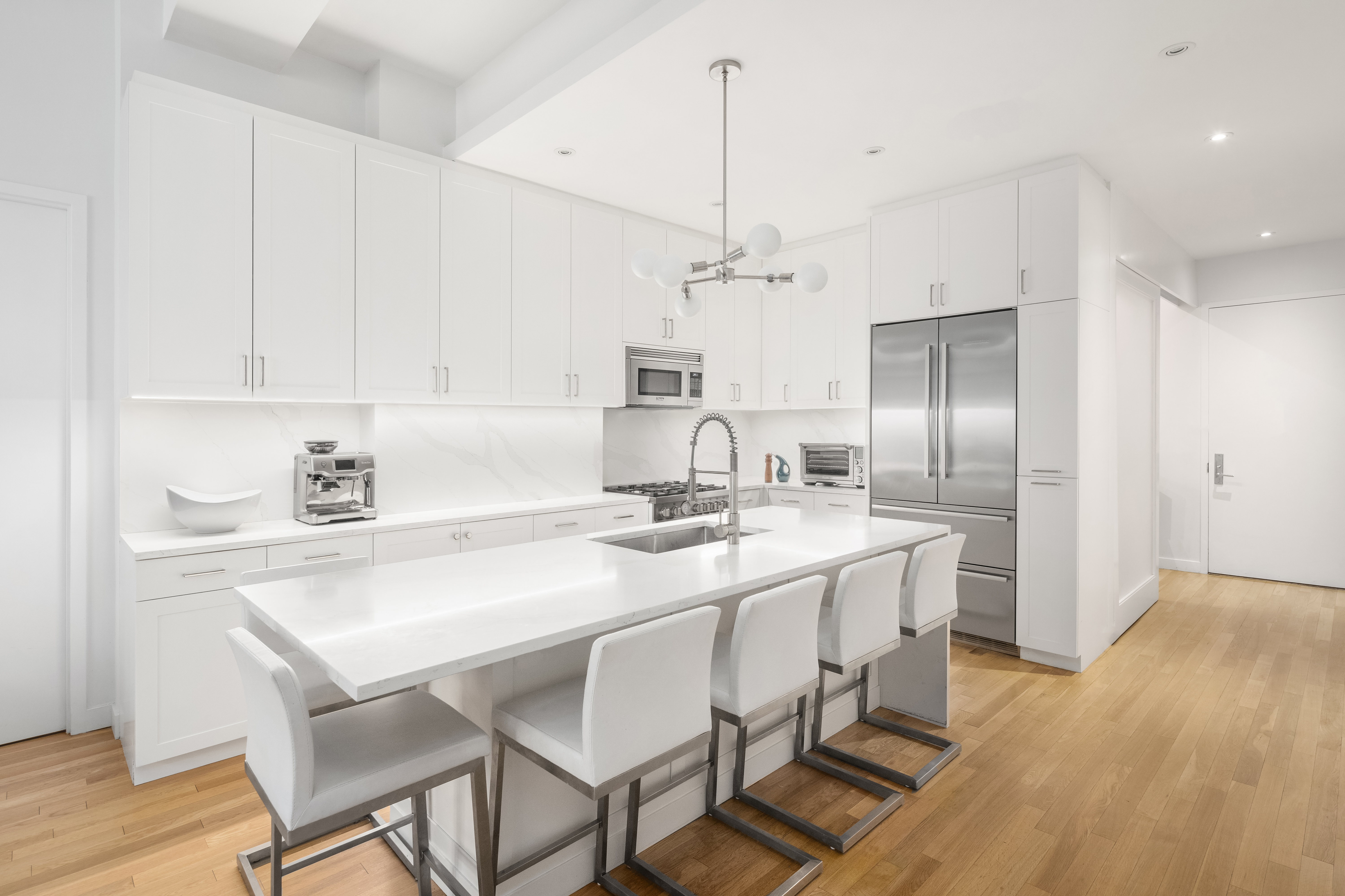 59 John Street, Unit 7D Manhattan, NY 10038 - Photo 2 of 10 a kitchen with kitchen island granite countertop a sink cabinets and stainless steel appliances