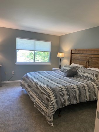 10 Beal's Cove Road, Unit E Hingham, MA 02043 - Photo 6 of 12 a bed sitting in a bedroom next to a window