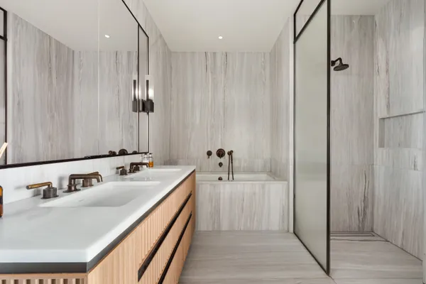 a en suite bathroom with a double vanity sink and a mirror
