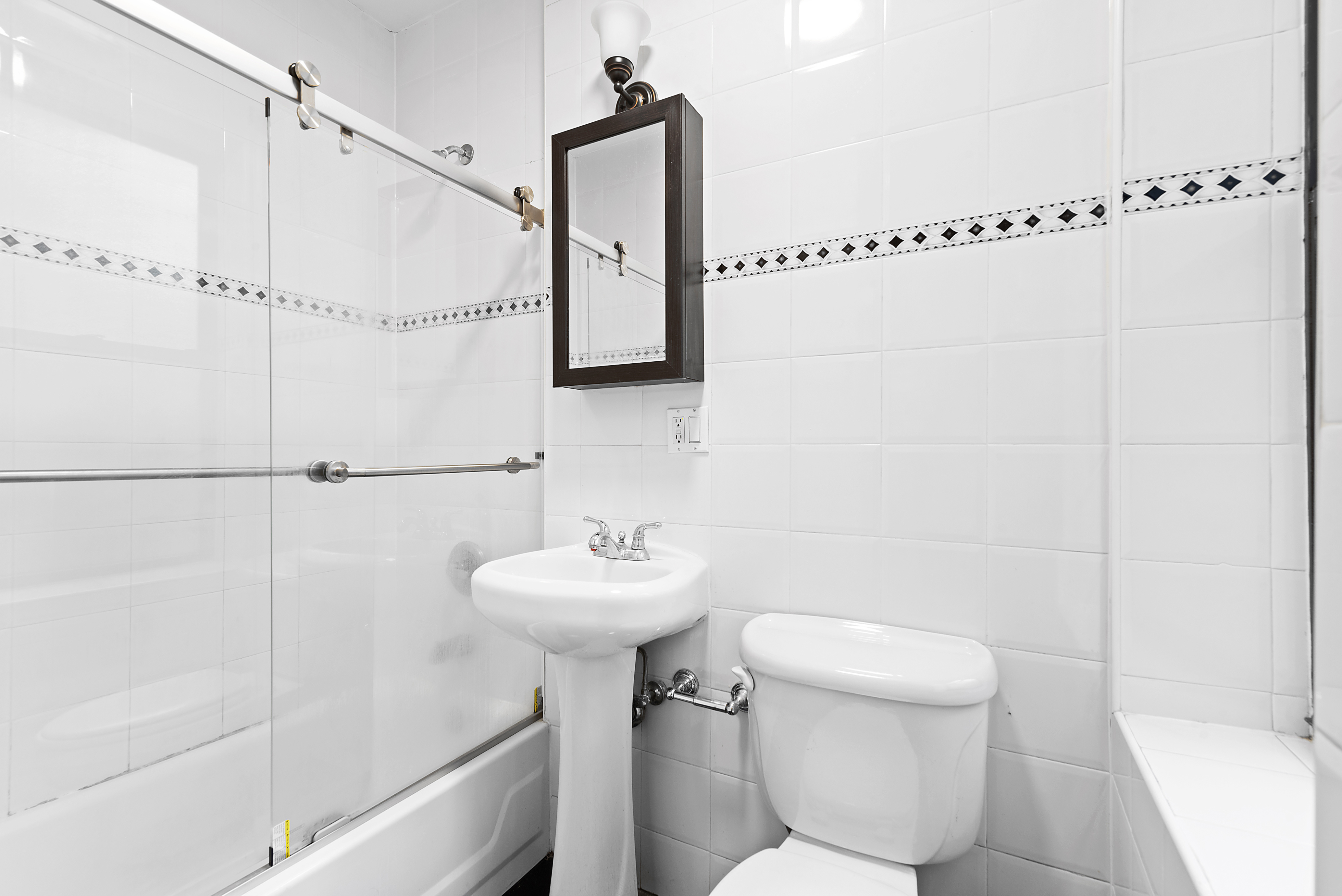 680 Riverside Drive, Unit 1E Manhattan, NY 10031 - Photo 6 of 6 a bathroom with a sink a mirror and a shower