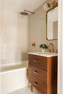 a bathroom with a tub sink and mirror
