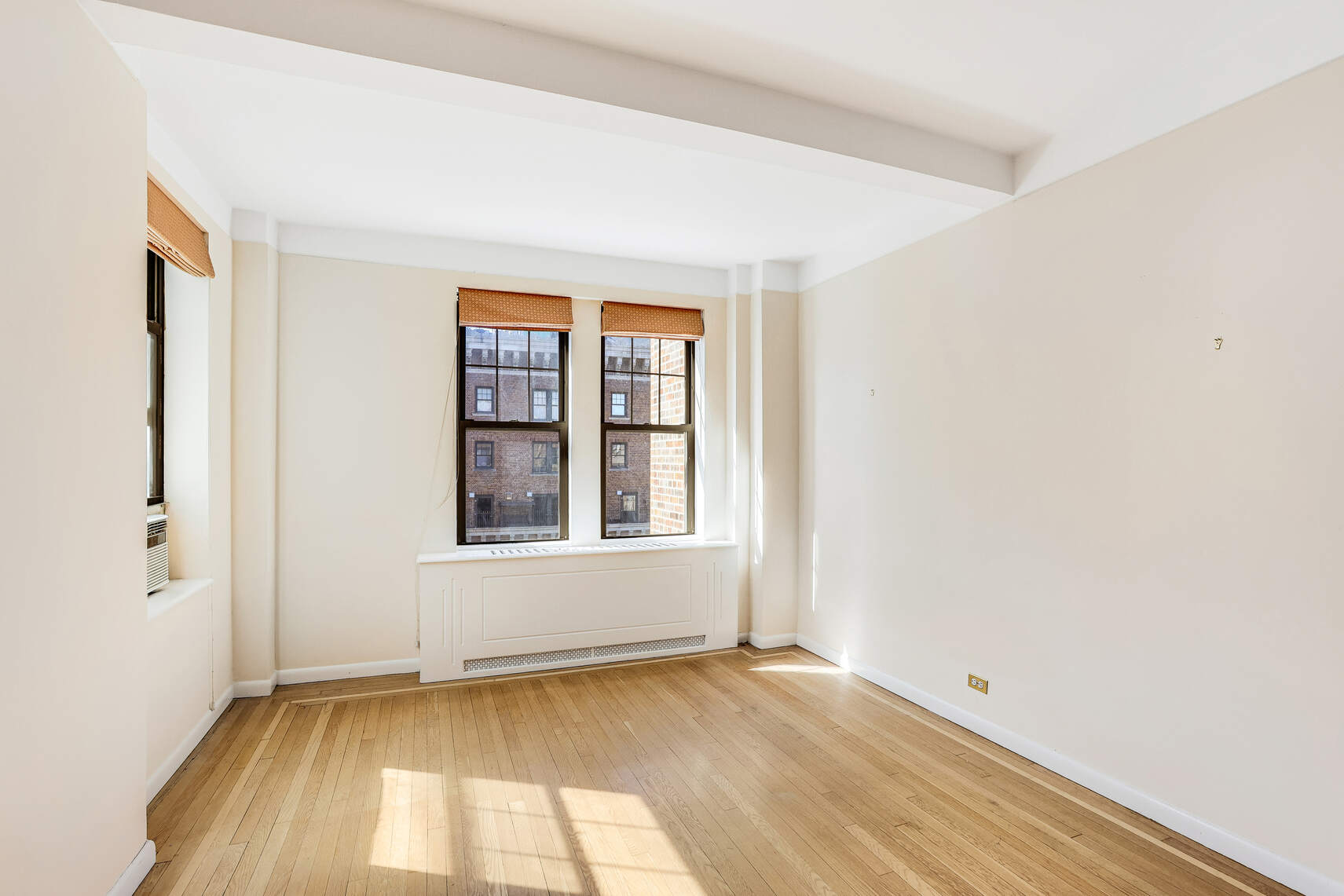 23 West 73rd Street, Unit 1405A Manhattan, NY 10023 - Photo 2 of 9 an empty room with wooden floor and windows