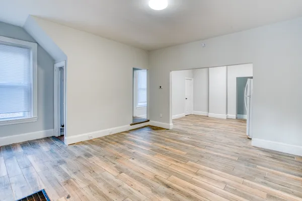 a view of empty room with wooden floor
