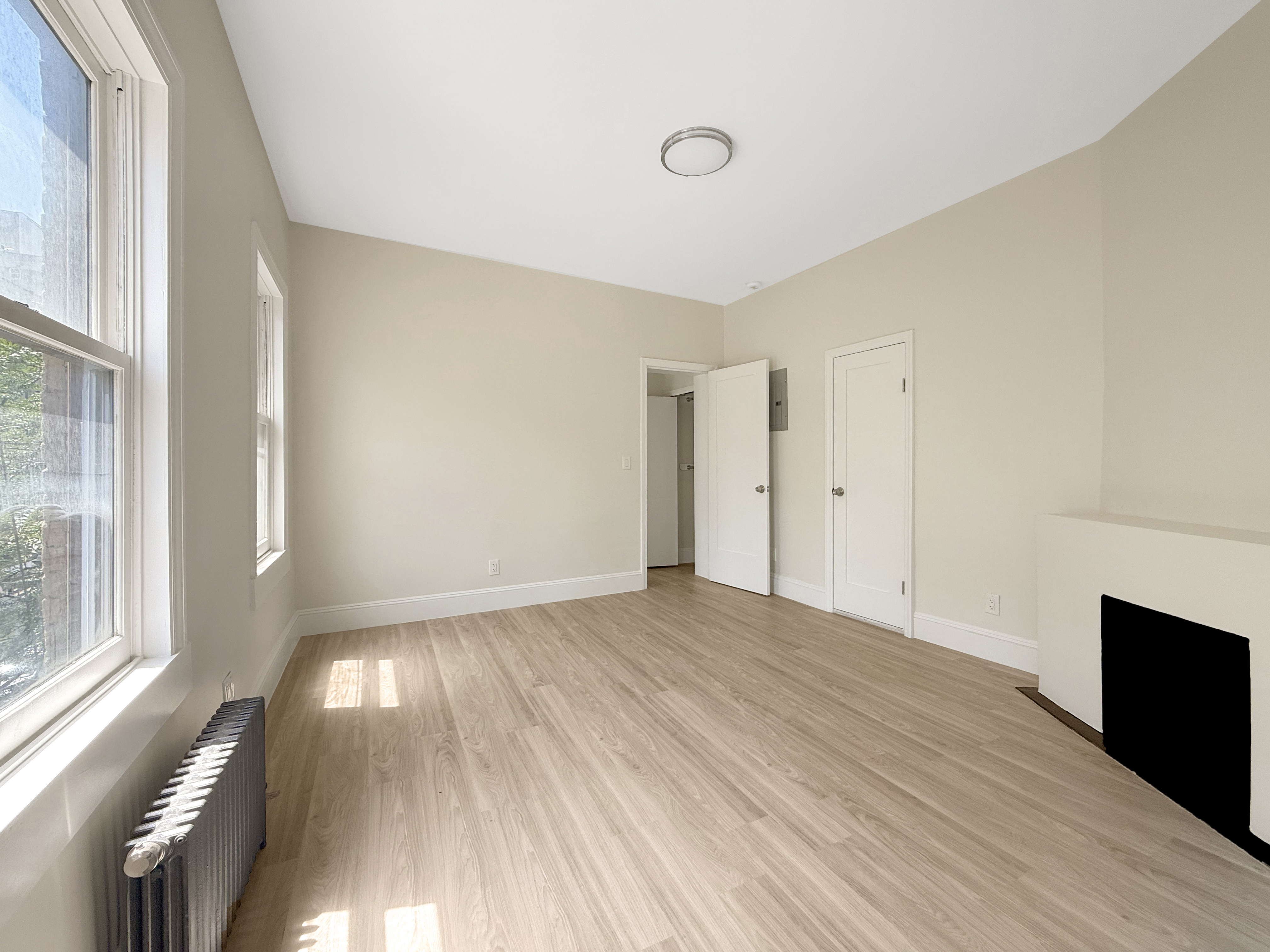 461 6th Avenue, Unit 3 Manhattan, NY 10011 - Photo 4 of 6 a view of an empty room with wooden floor and a window