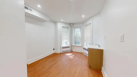 a view of a room with wooden floor and a window