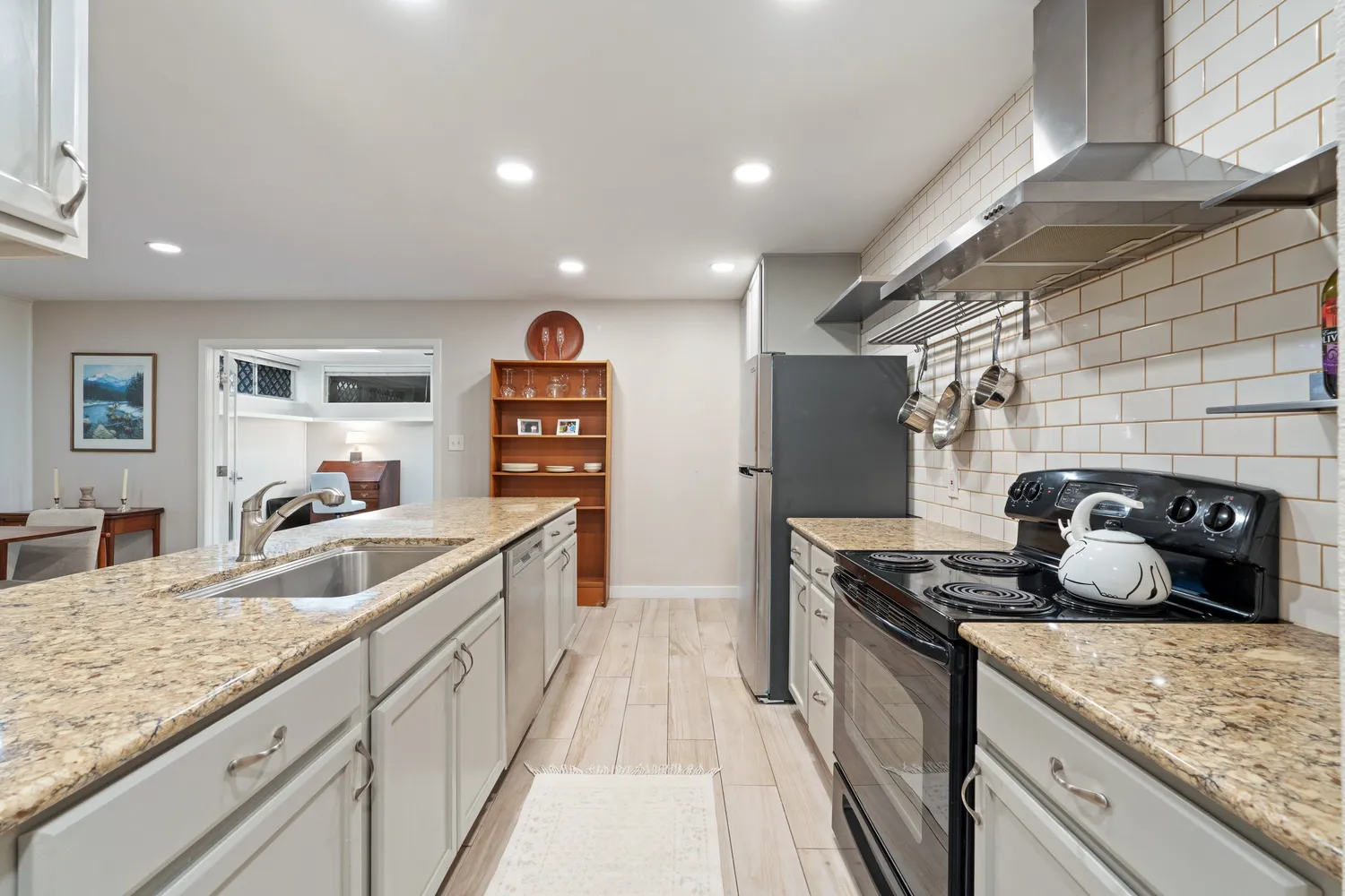 a kitchen with sink a refrigerator and wooden floor