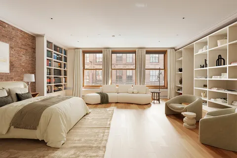 a spacious bedroom with a bed couch and a large window