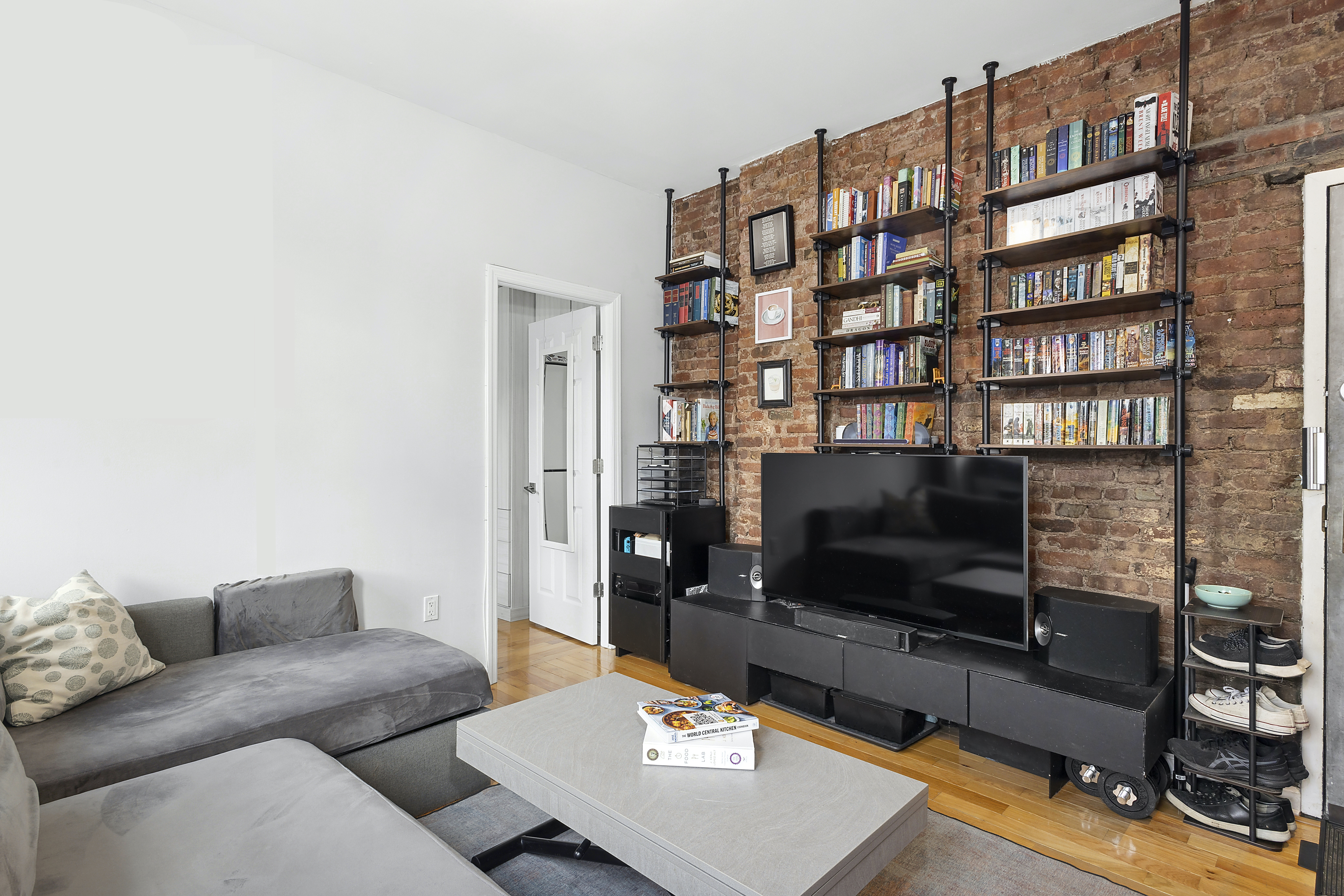 124 Thompson Street, Unit 21 Manhattan, NY 10012 - Photo 2 of 10 a living room with furniture and a flat screen tv