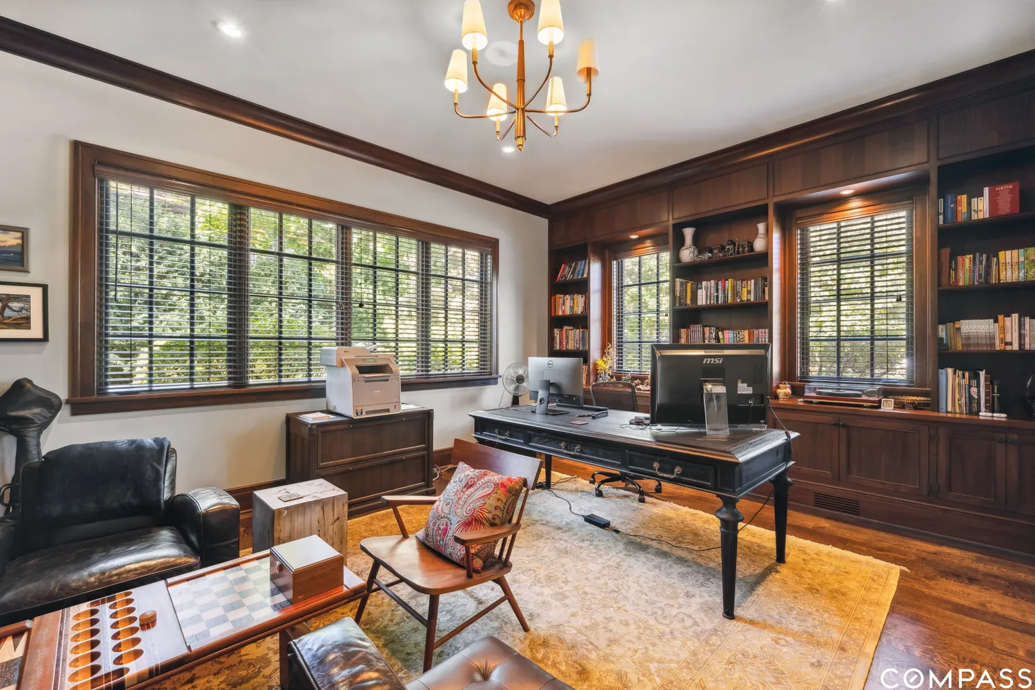 a living room with furniture a table and large windows