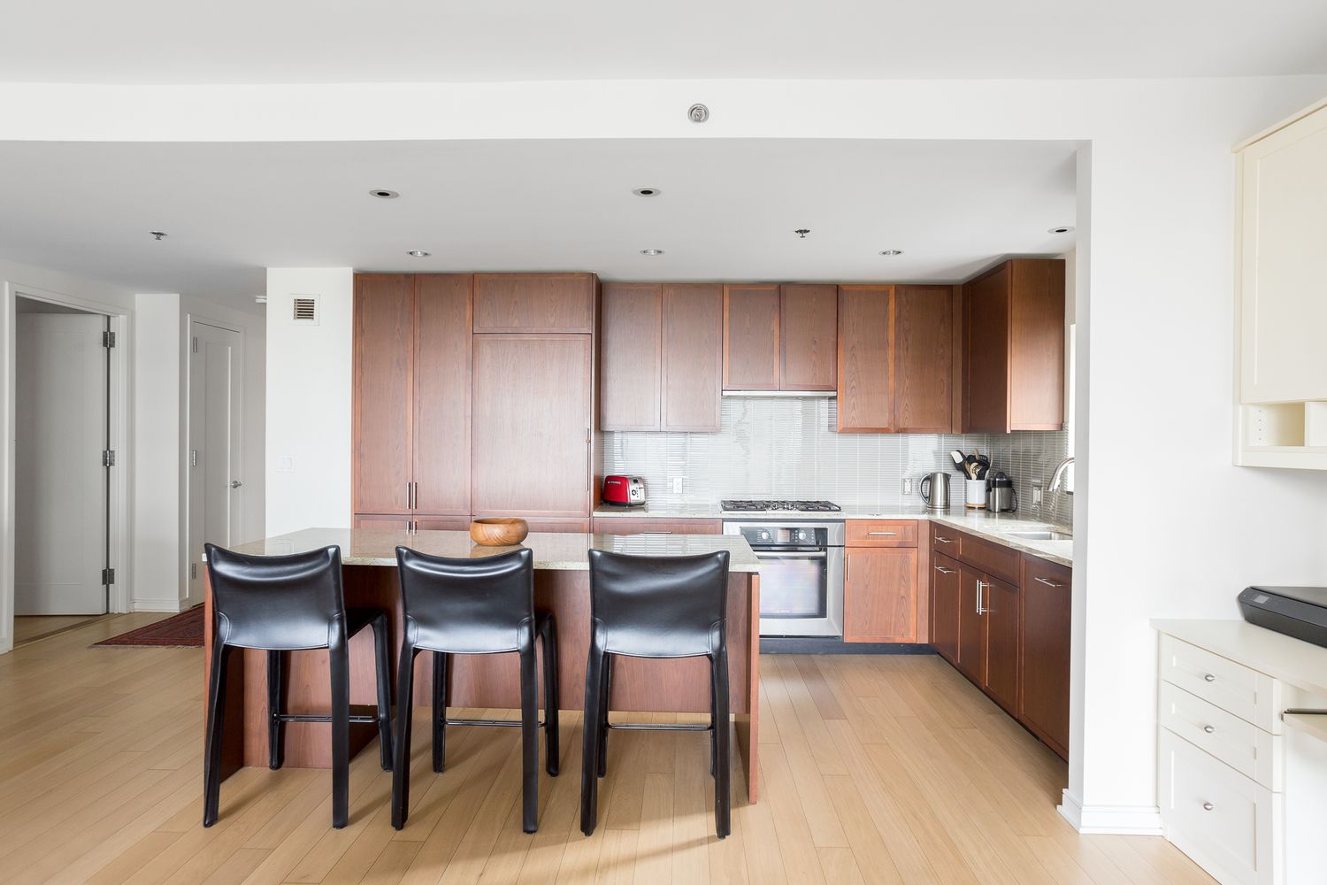 a kitchen with a sink and chairs