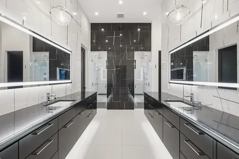 a bathroom with double vanity and a bathtub