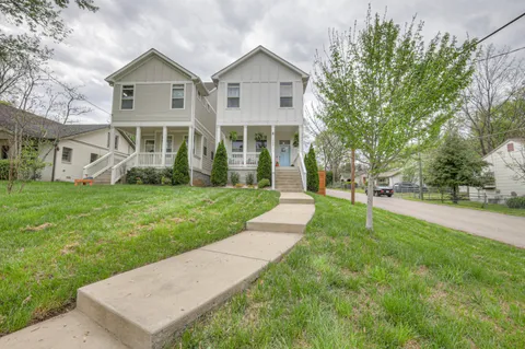 a front view of a house with a yard and trees